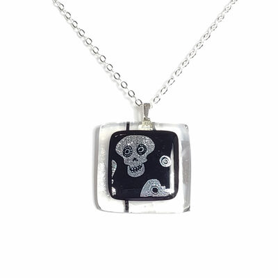 Dichroic skulls on clear striped fused glass necklace